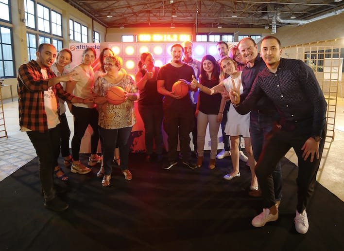 Groupe de collègues devant le mur digital après une partie de basket