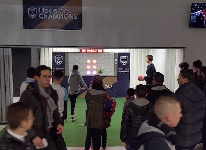 Groupe de spectateurs passant devant le mur digital dans les couloirs du stade des Girondins de Bordeaux