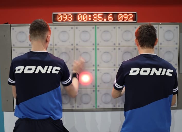 Duo de sportifs jouant au jeu de réflexe sur le mur digital