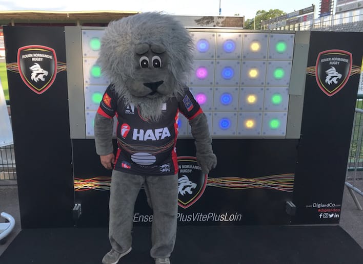 Mascotte du Rouen Normandie Rugby posant devant le mur digital