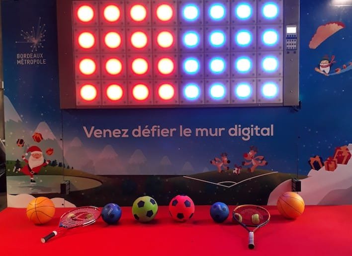 Ballons et Raquettes disposées devant le mur digital