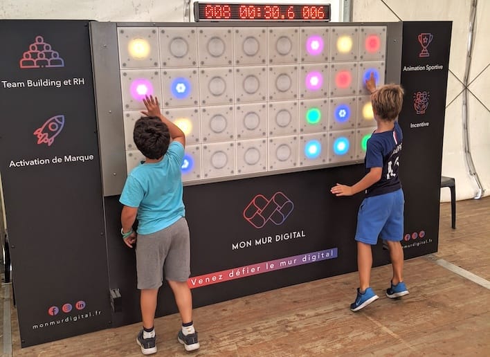 Deux jeunes garçons jouant au mur digital à un jeu de réflexe