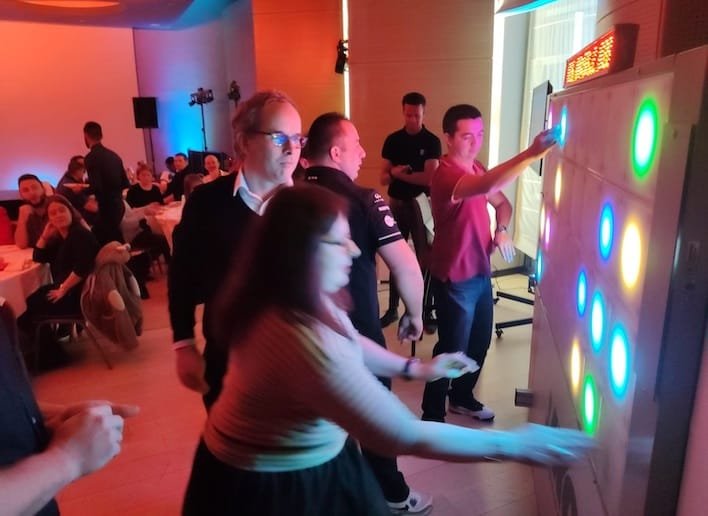 Groupe de personne jouant au mur digital lors d'une soirée